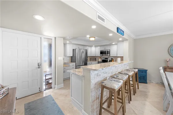 a kitchen with stainless steel appliances kitchen island granite countertop a refrigerator and a stove top oven