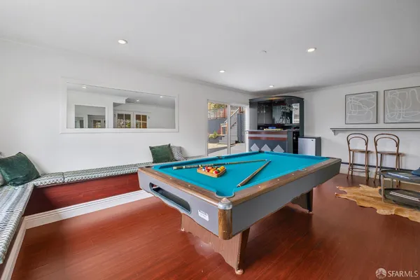 a roof deck with a dining table and chairs with wooden floor