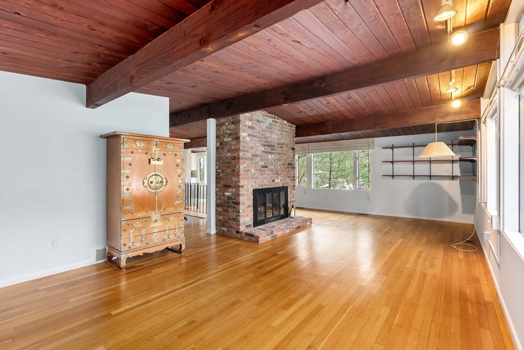 34 Bellingham Road Brookline, MA 02467 - Photo 17 of 33 an empty room with wooden floor and fireplace