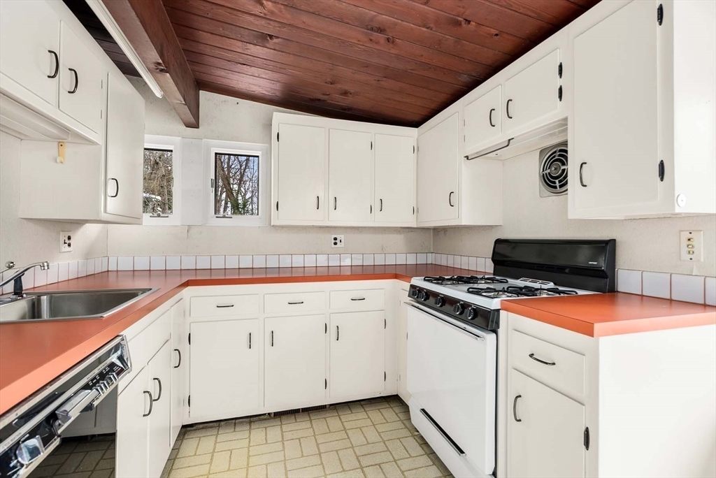 34 Bellingham Road Brookline, MA 02467 - Photo 20 of 33 a kitchen with granite countertop white cabinets and white appliances