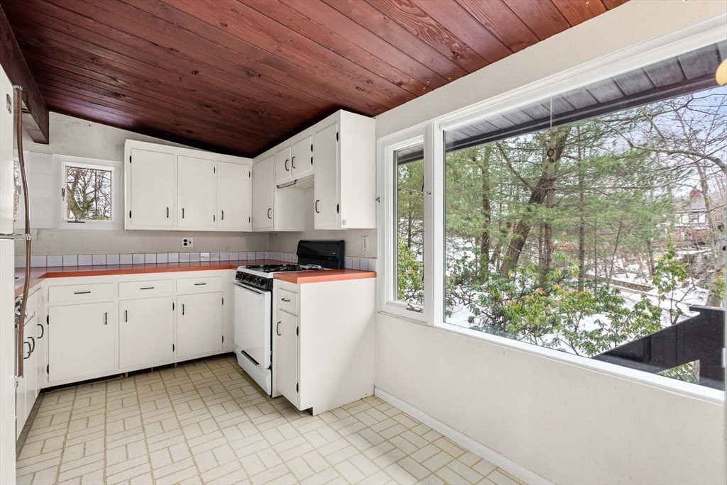 34 Bellingham Road Brookline, MA 02467 - Photo 21 of 33 a kitchen with white cabinets and wooden floors