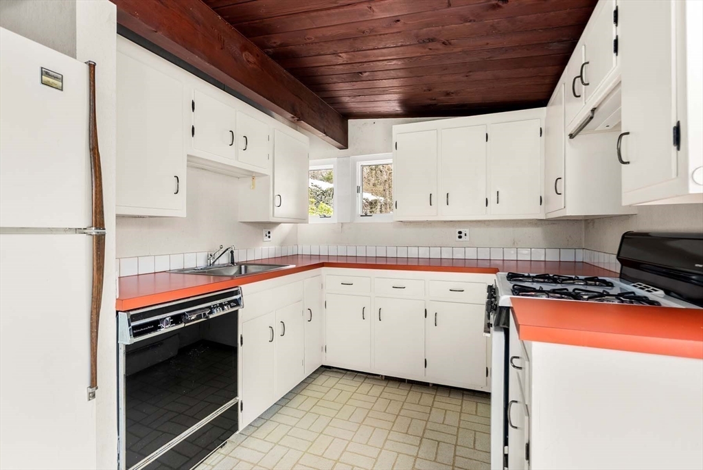 34 Bellingham Road Brookline, MA 02467 - Photo 22 of 33 a kitchen with granite countertop a white stove top oven and white cabinets