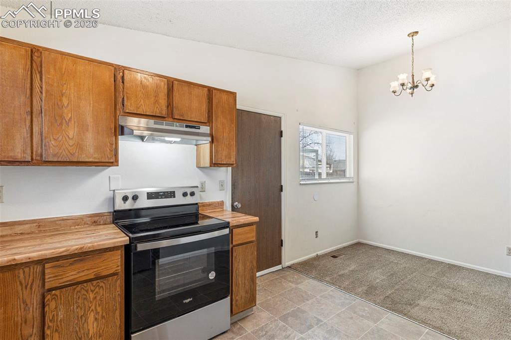6745 Parkridge Court Colorado Springs, CO 80915 - Photo 11 of 23 a kitchen with granite countertop a stove and a refrigerator