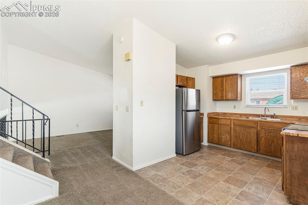 6745 Parkridge Court Colorado Springs, CO 80915 - Photo 7 of 23 a view of a kitchen with a sink and dishwasher a refrigerator with white cabinets