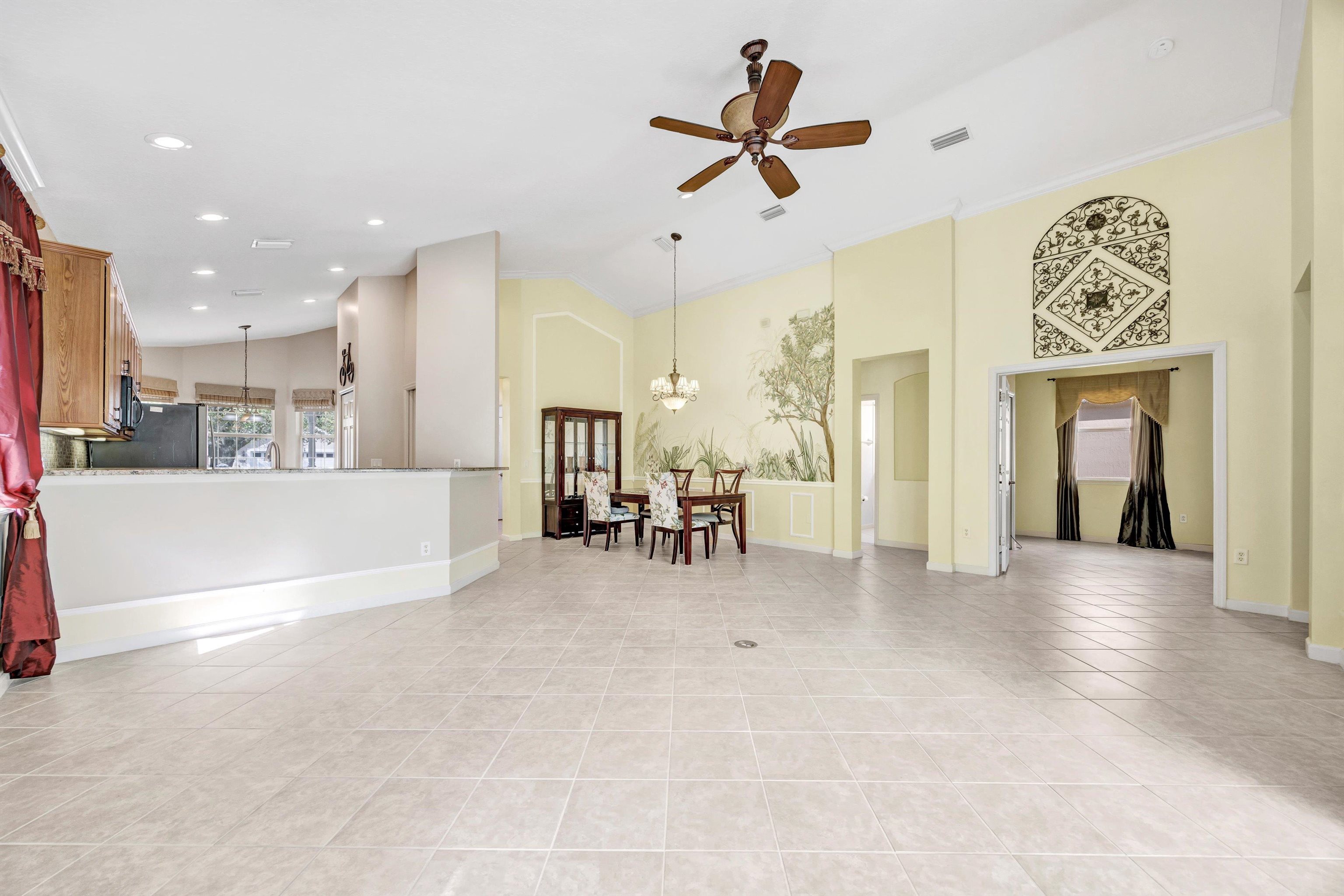 608 Copperhead Circle St. Augustine, FL 32092 - Photo 12 of 65 This picture of the living area is taken with the lanai directly behind the photographer, facing southwest. It gives you a clear indication of the expansiveness of the room and the lengthy kitchen granite bar.
