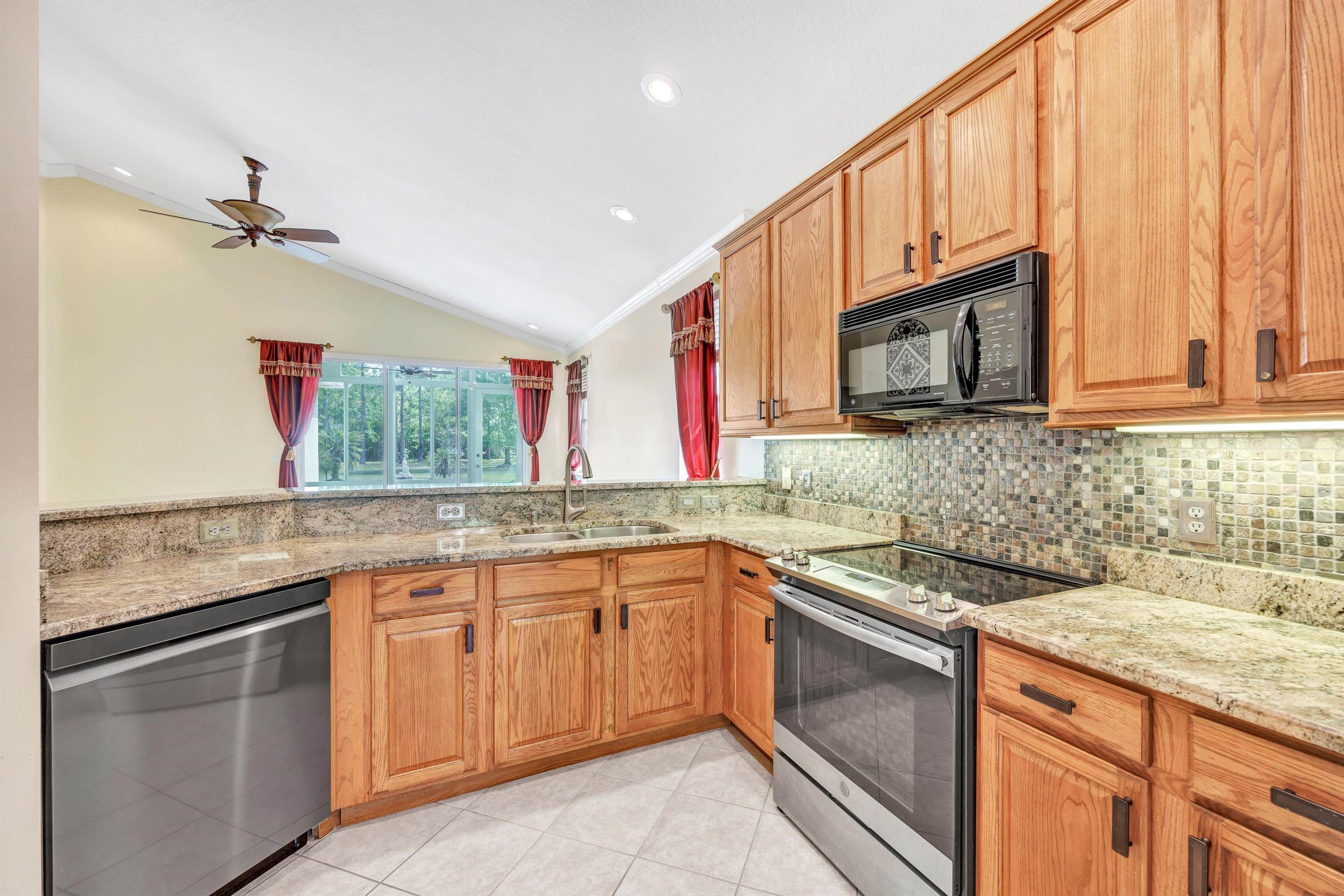 608 Copperhead Circle St. Augustine, FL 32092 - Photo 20 of 65 Another picture of the kitchen, this one with more counter space visible, along with the dishwasher, oven and built in microwave. Bar seating is on the other side of the deep stainless double sink straight ahead.