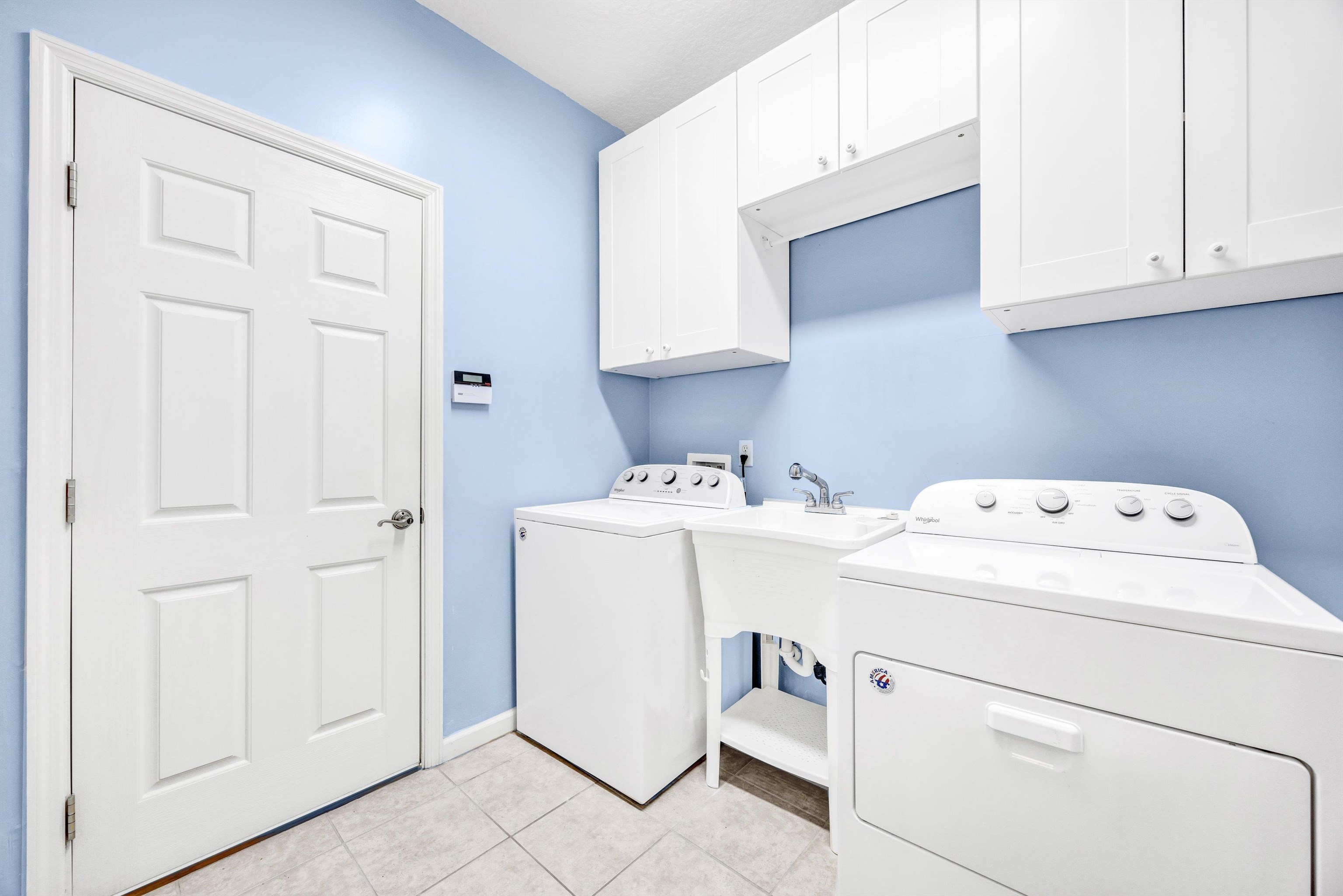 608 Copperhead Circle St. Augustine, FL 32092 - Photo 21 of 65 The laundry room can be entered through the garage or the home. It houses several cabinets, a matching set of newer washer/dryer, and a full utility sink.