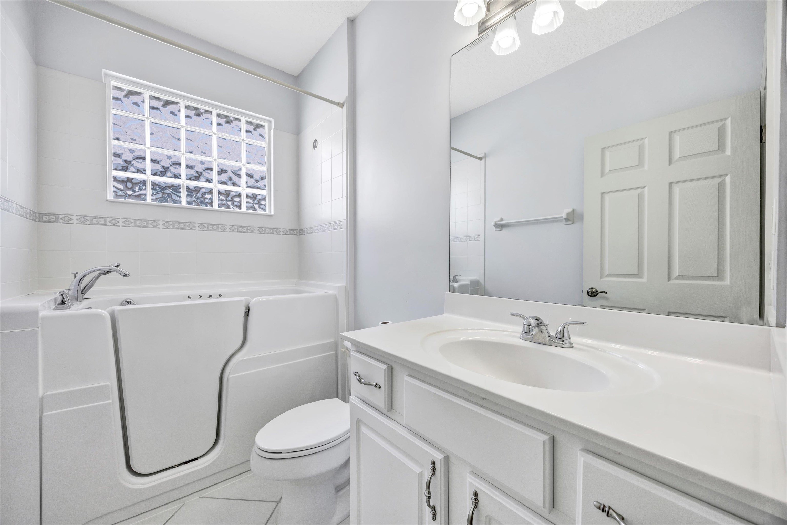 608 Copperhead Circle St. Augustine, FL 32092 - Photo 32 of 65 The guest bath is situated between bedroom 2 and 3. It has a custom walk-in shower with a fully jetted jacuzzi bath.