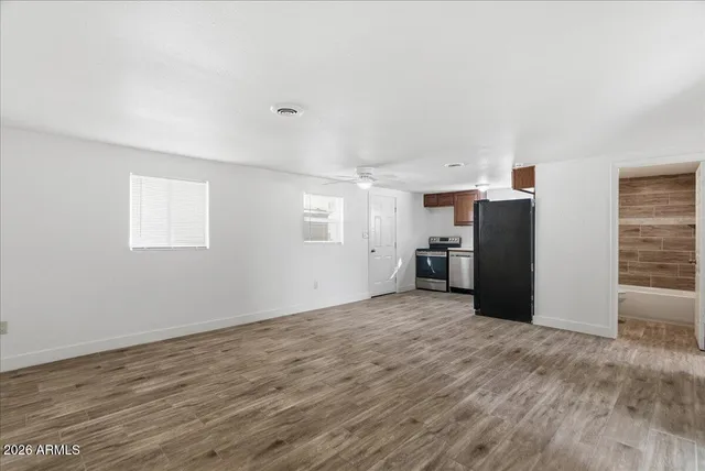 a view of a kitchen with refrigerator and window