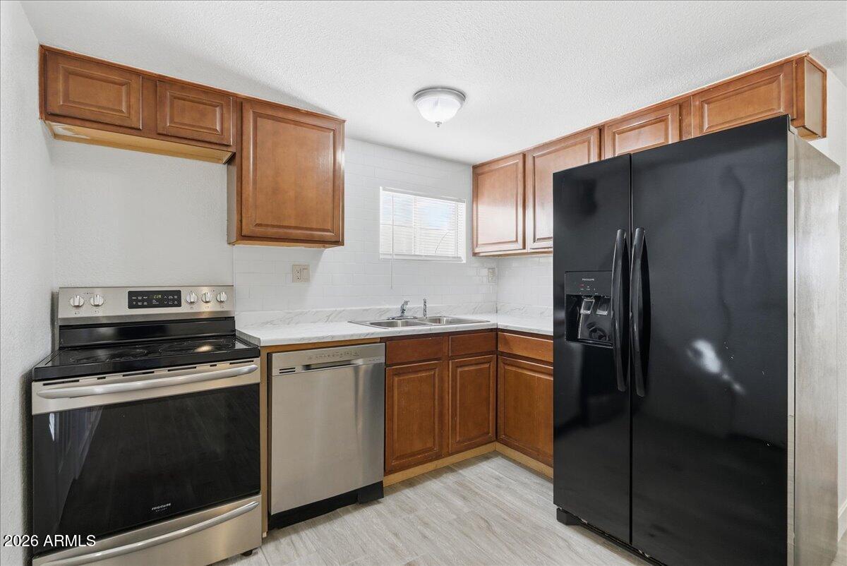 451 East 10th Avenue Apache Junction, AZ 85119 - Photo 8 of 21 a kitchen with stainless steel appliances granite countertop a refrigerator stove and sink