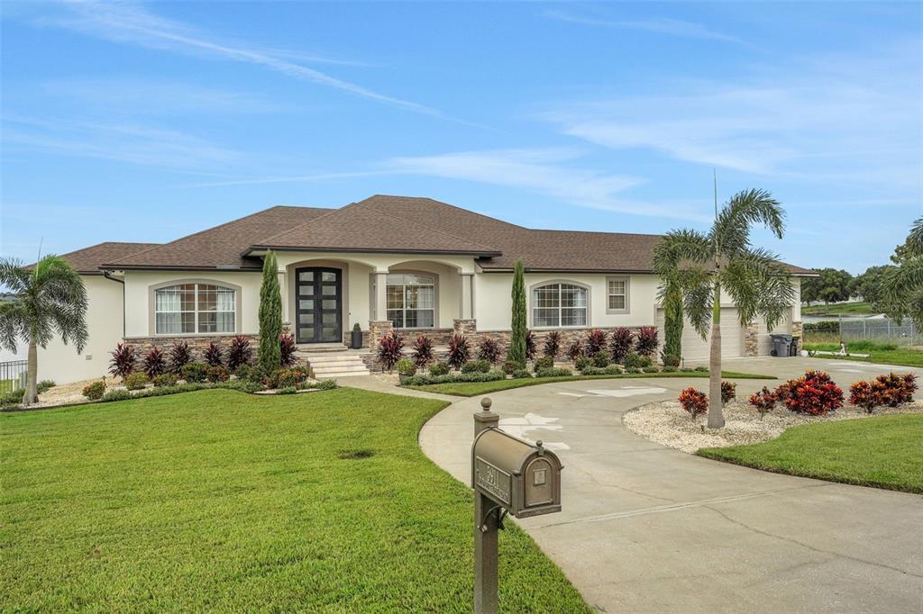 5911 Old Berkley Road Auburndale, FL 33823 - Photo 1 of 91 a front view of a house with a garden and patio