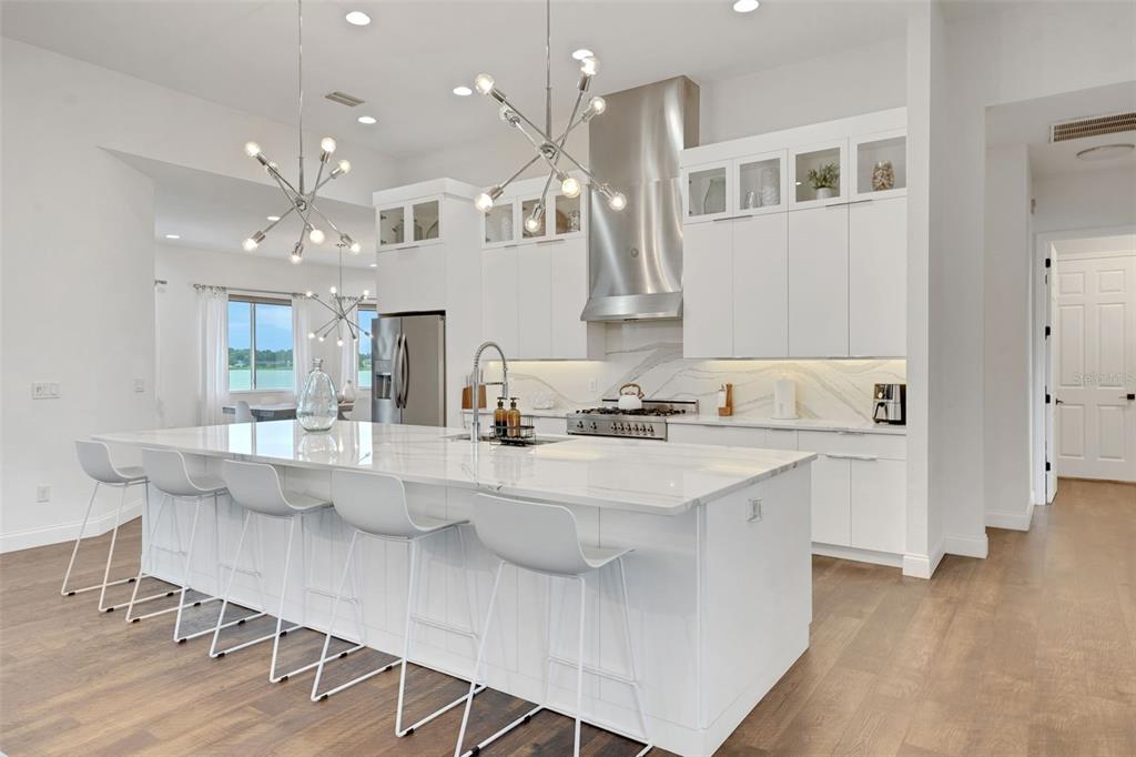 5911 Old Berkley Road Auburndale, FL 33823 - Photo 15 of 91 a kitchen with stainless steel appliances kitchen island granite countertop a table chairs sink and wooden floor