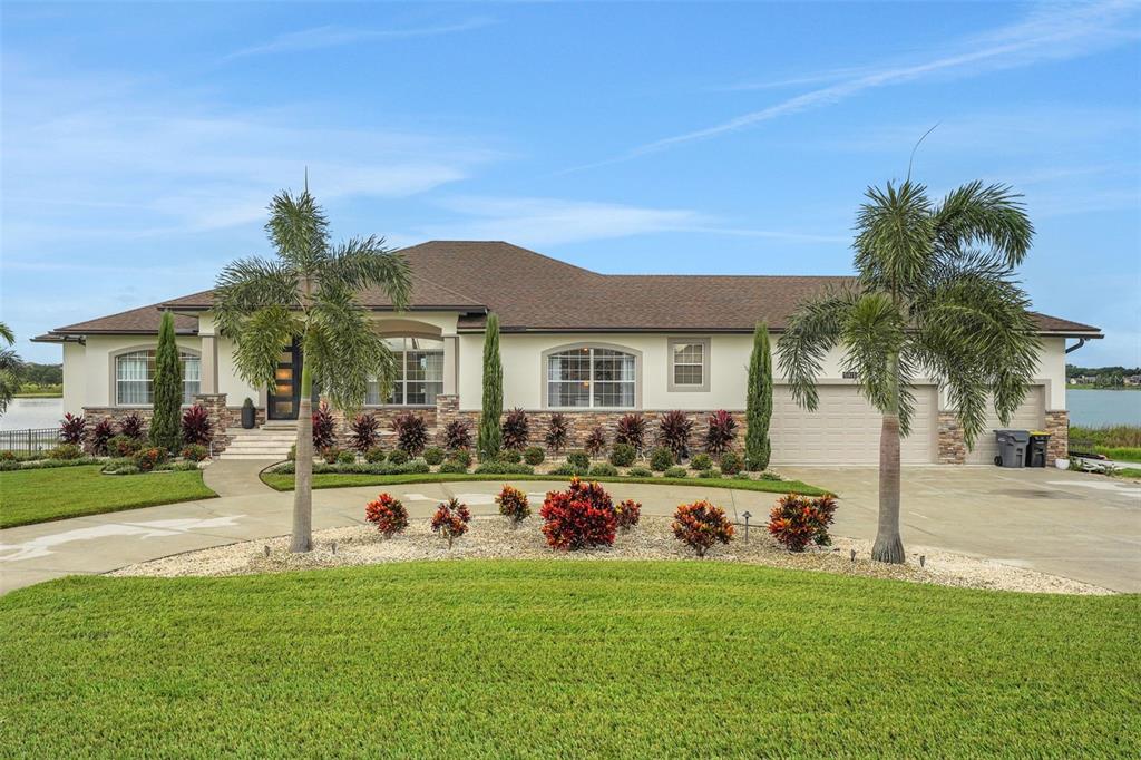5911 Old Berkley Road Auburndale, FL 33823 - Photo 2 of 91 a front view of a house with a garden and patio