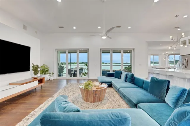 a kitchen with stainless steel appliances kitchen island granite countertop a table chairs sink and wooden floor