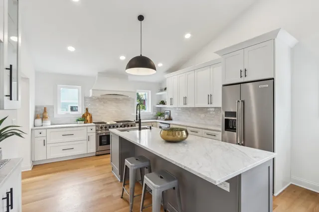 a kitchen with a center island appliances and cabinets