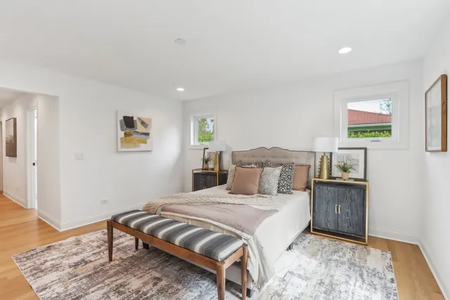 a bedroom with a bed painting on wall and a wooden floor