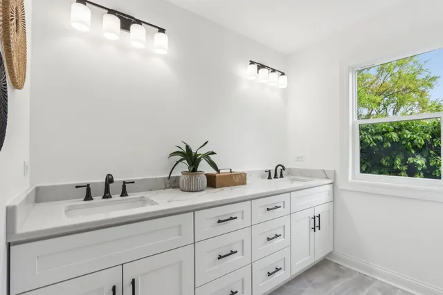 a bathroom with a double vanity sink and a mirror