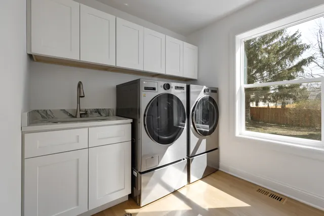 a utility room with sink dryer and washer