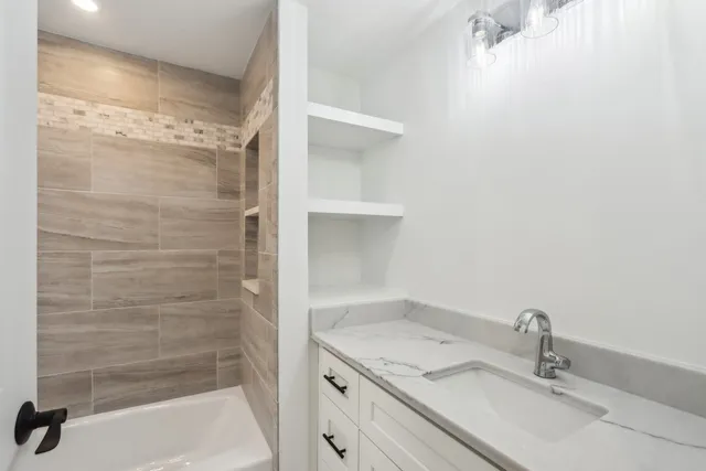 a bathroom with a granite countertop sink a mirror and shower