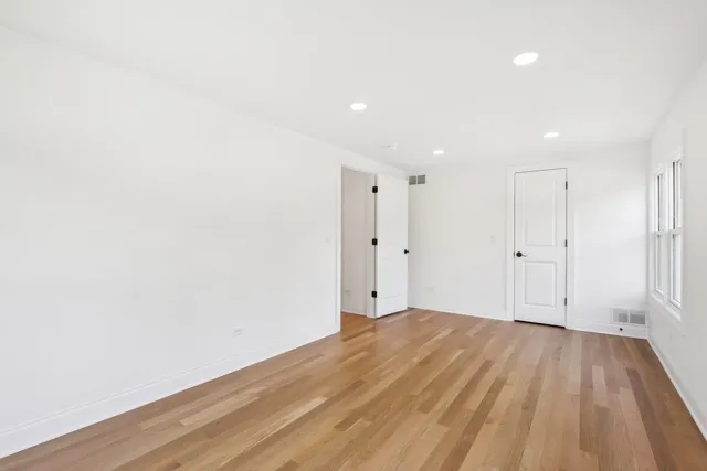a view of room with wooden floor and white walls
