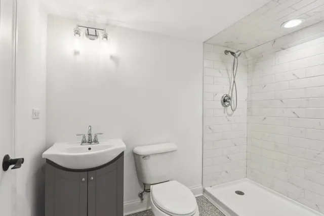 a bathroom with a shower sink mirror and toilet