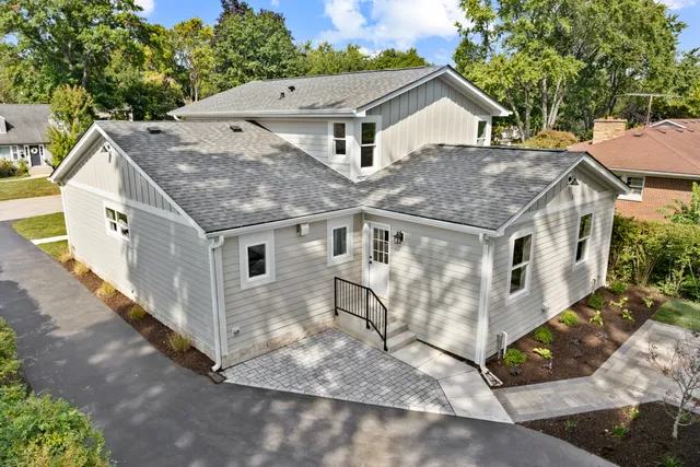a aerial view of a house with a yard and large tree
