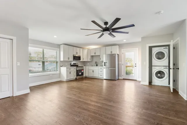 a view of a kitchen with refrigerator and wooden floor