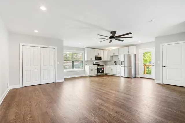 a view of empty room with wooden floor and ceiling fan