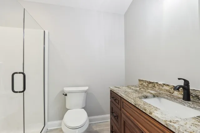 a bathroom with a granite countertop sink and a toilet