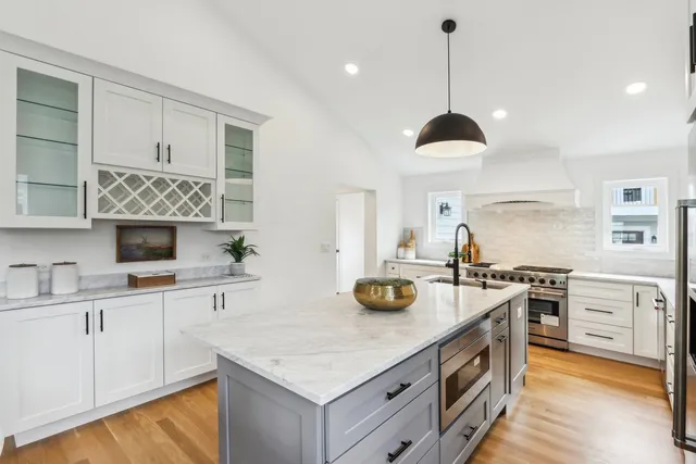 a kitchen with a sink stove and wooden floor