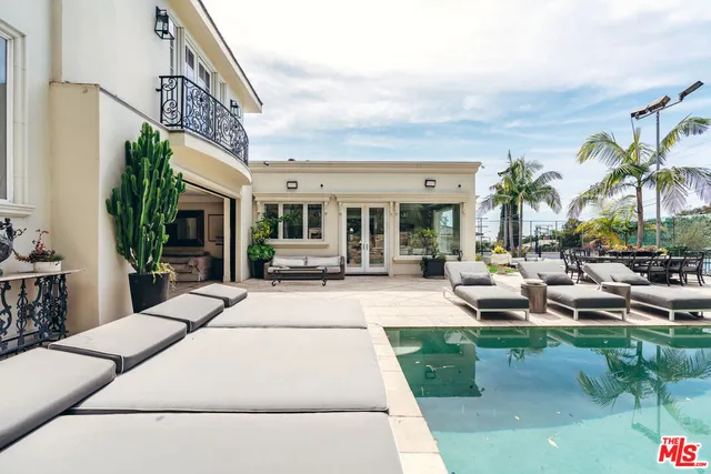 a living room with patio furniture and a potted plant