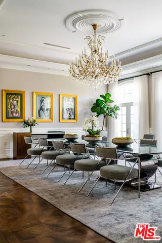 a living room with furniture a chandelier and a large window