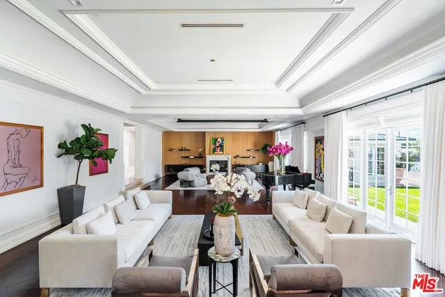 a living room with fireplace furniture and a large window