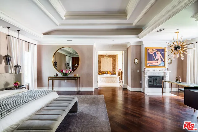 a bedroom with a large bed a potted plant and dresser