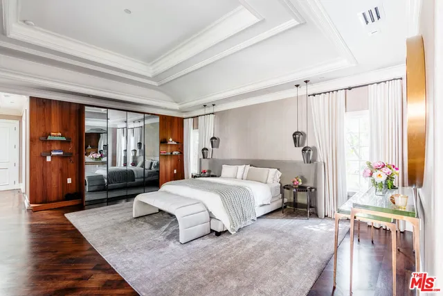 a bedroom with a bed a mirror and a window