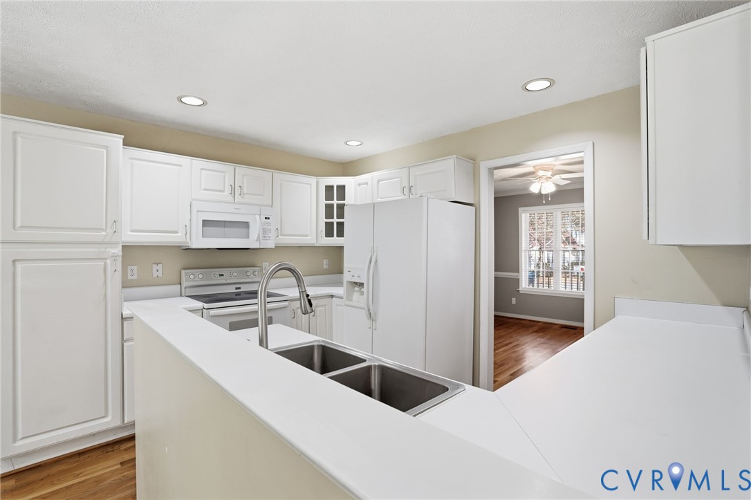 6093 Homehills Road Mechanicsville, VA 23111 - Photo 14 of 50 a kitchen with a sink a stove a refrigerator and white cabinets