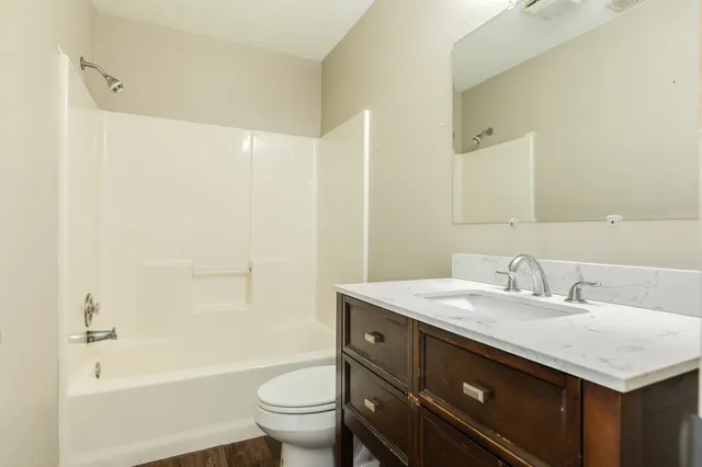 a bathroom with a sink toilet vanity and shower
