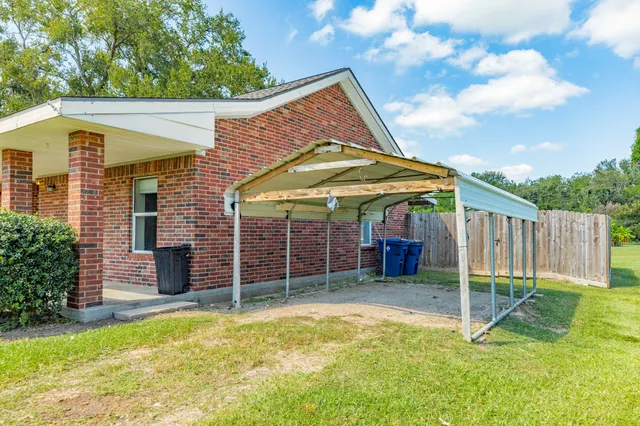 a view of a house with a backyard and wooden fence