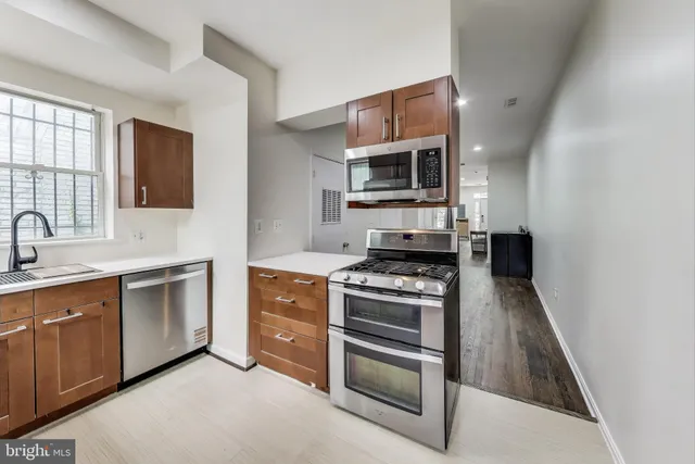a kitchen with stainless steel appliances a stove microwave and sink