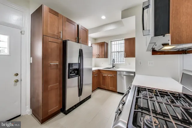 a kitchen with granite countertop a refrigerator stove and sink