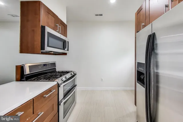 a kitchen with stainless steel appliances a refrigerator stove and microwave