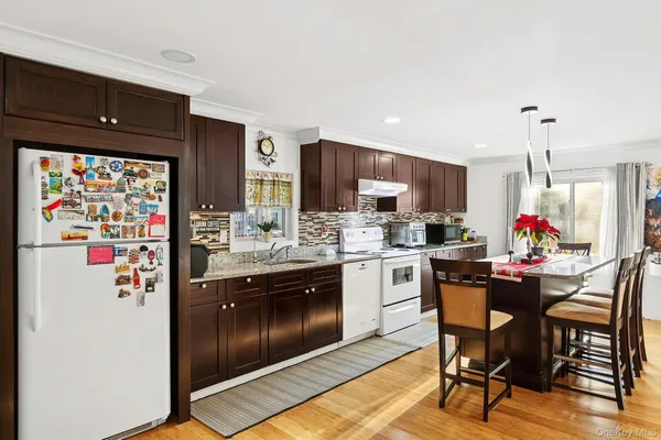 a kitchen with stainless steel appliances granite countertop a refrigerator and a stove top oven