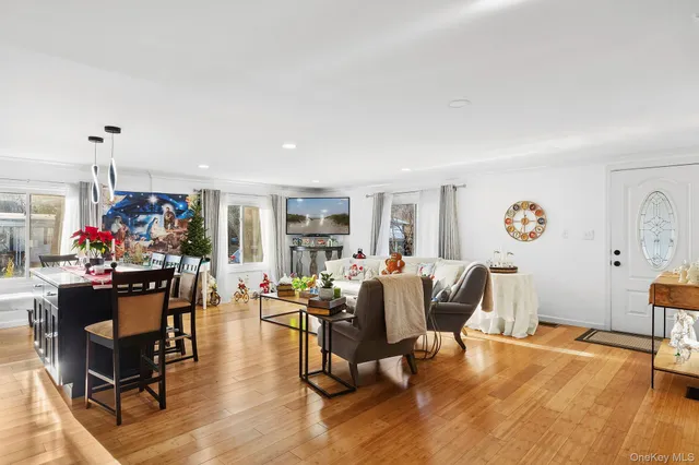 a living room with furniture and a dining table with wooden floor