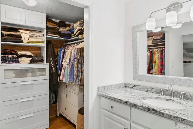 a view of walk in closet with clothes and shoes
