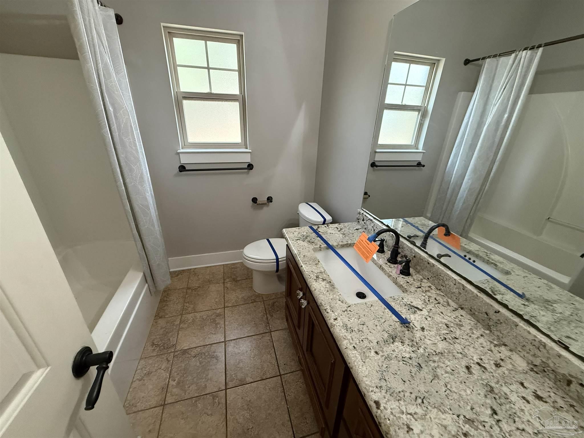7223 Martin Road Milton, FL 32570 - Photo 14 of 28 a bathroom with a granite countertop sink toilet and window