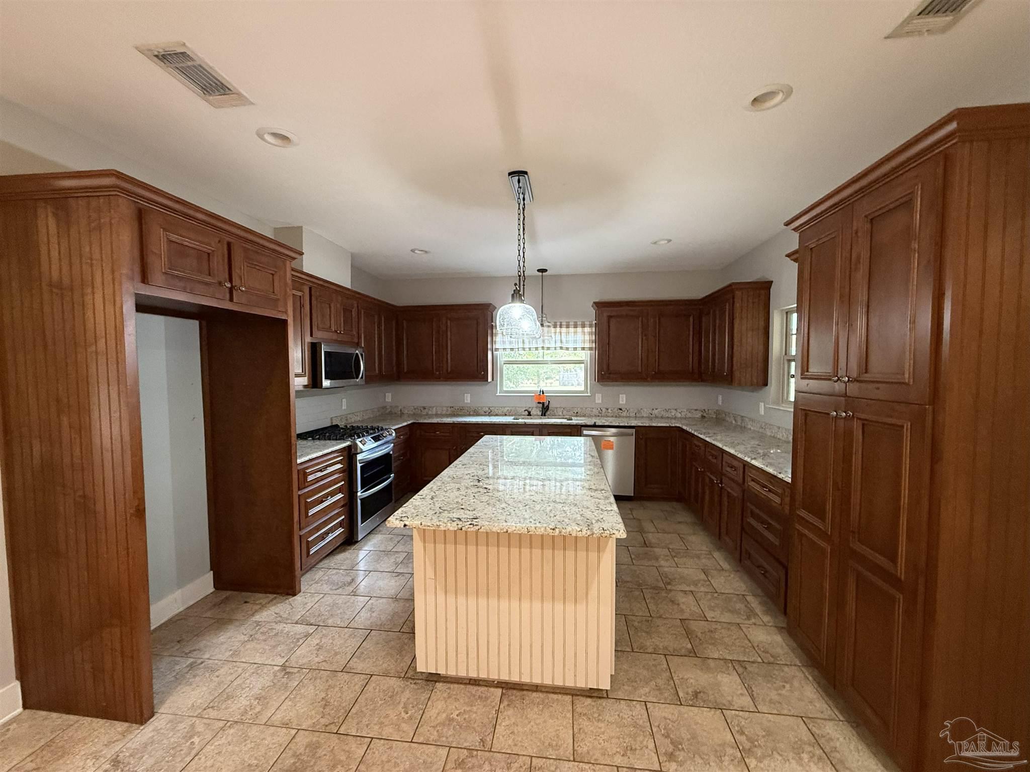 7223 Martin Road Milton, FL 32570 - Photo 19 of 28 a large kitchen with stainless steel appliances granite countertop a refrigerator and a sink