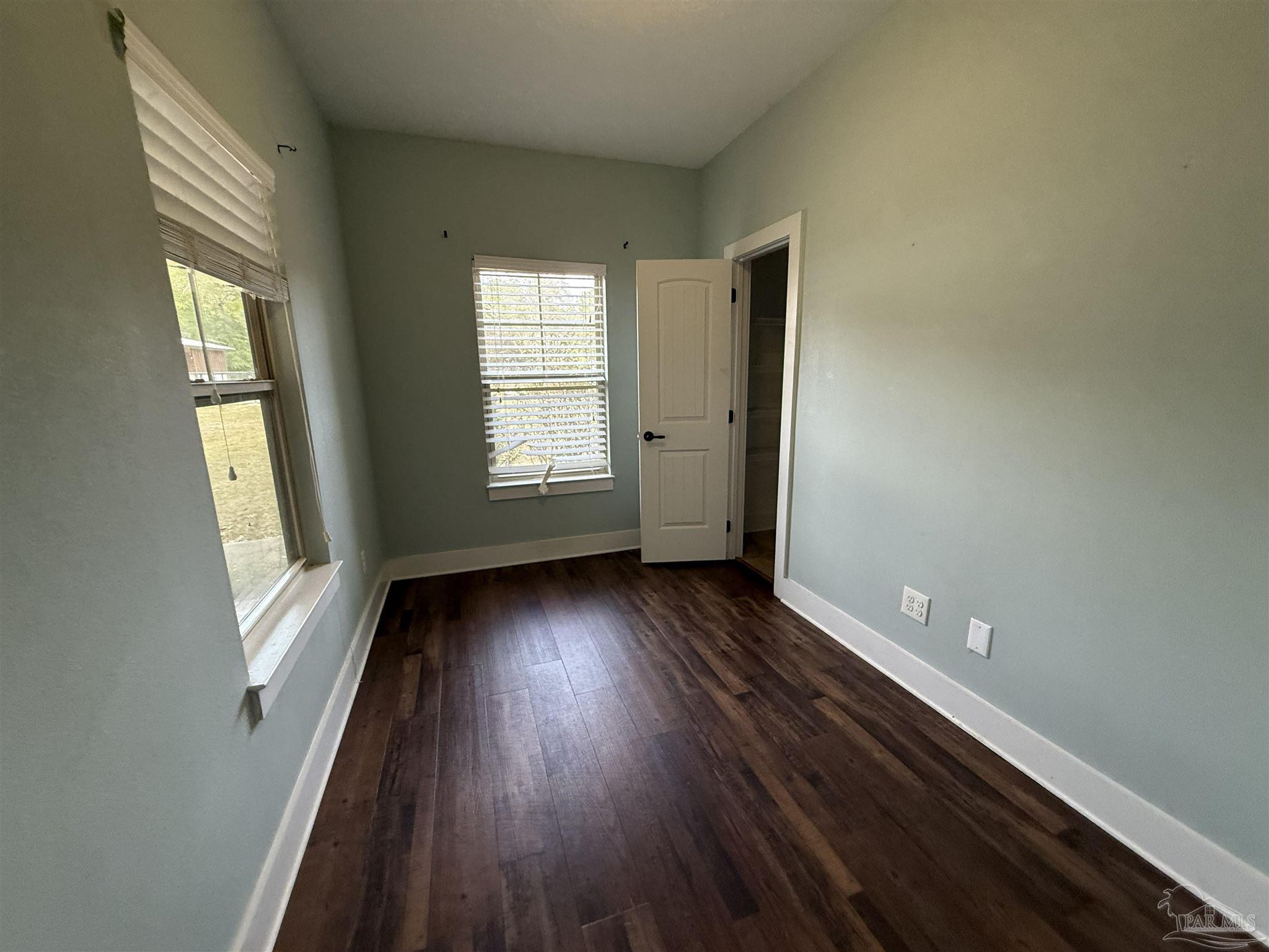 7223 Martin Road Milton, FL 32570 - Photo 23 of 28 an empty room with wooden floor and windows