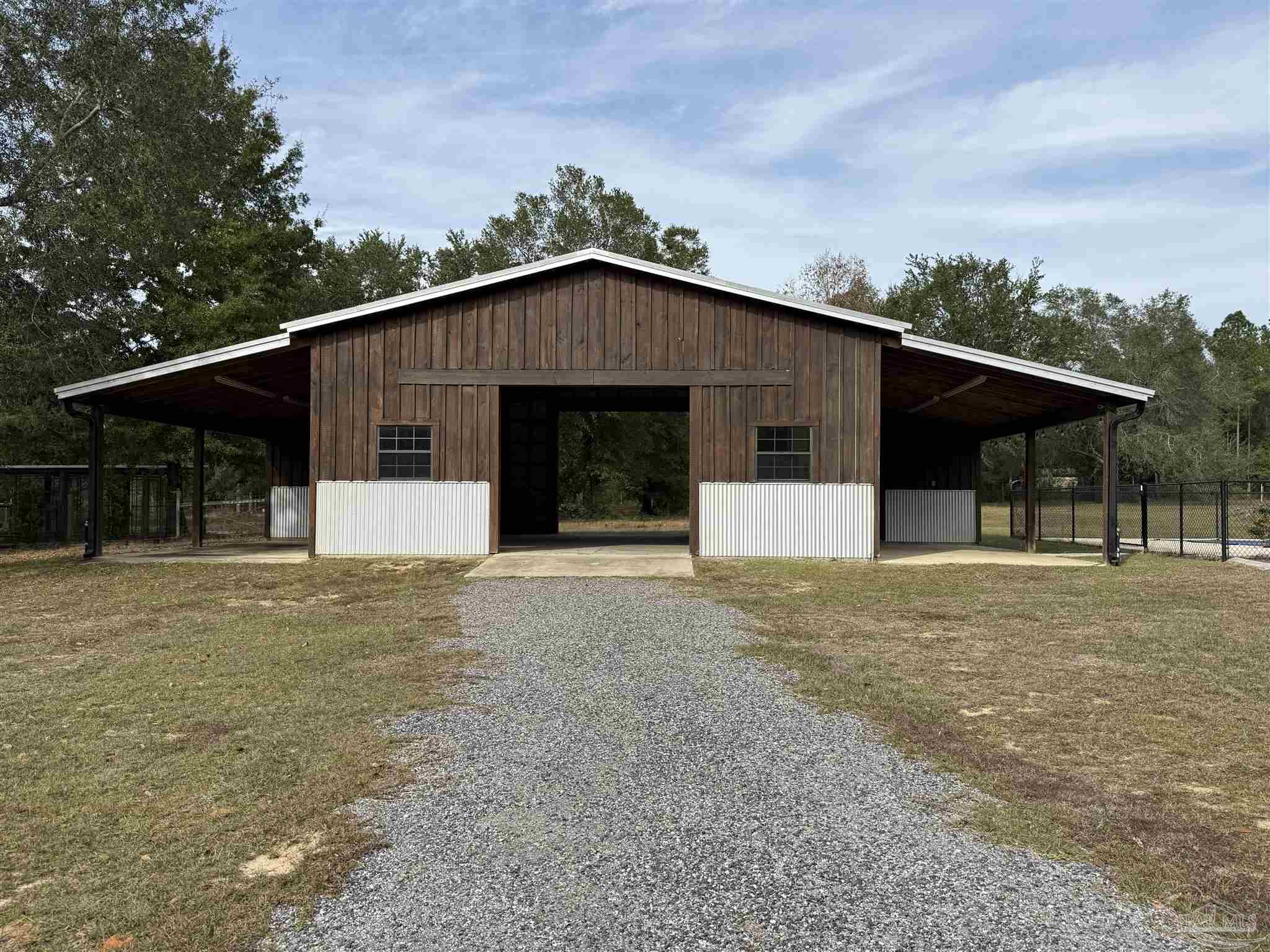7223 Martin Road Milton, FL 32570 - Photo 27 of 28 a front view of a house with a garden and trees