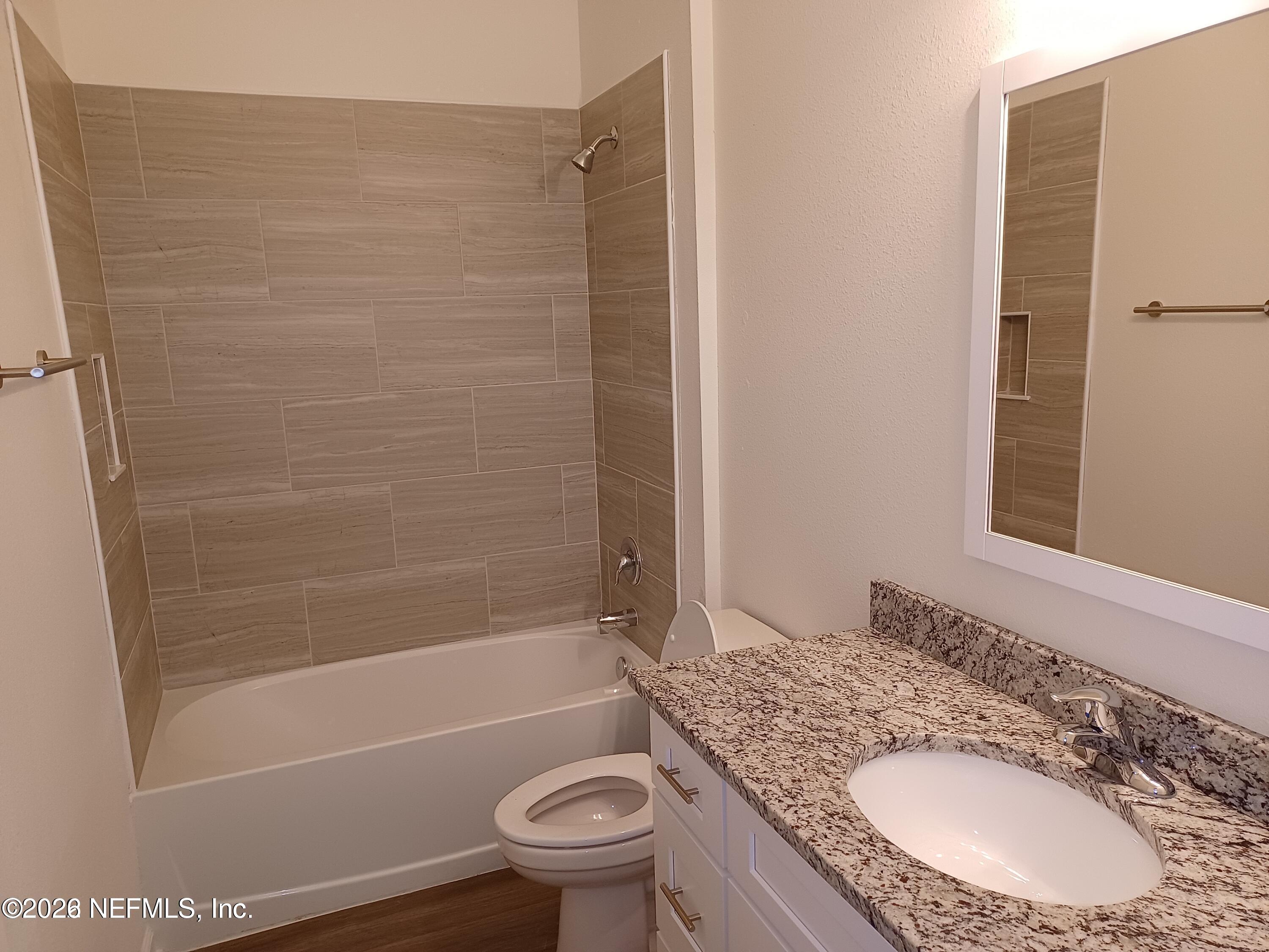 3006 Alonso Road Jacksonville, FL 32216 - Photo 12 of 16 a bathroom with a granite countertop bathtub sink vanity mirror and toilet