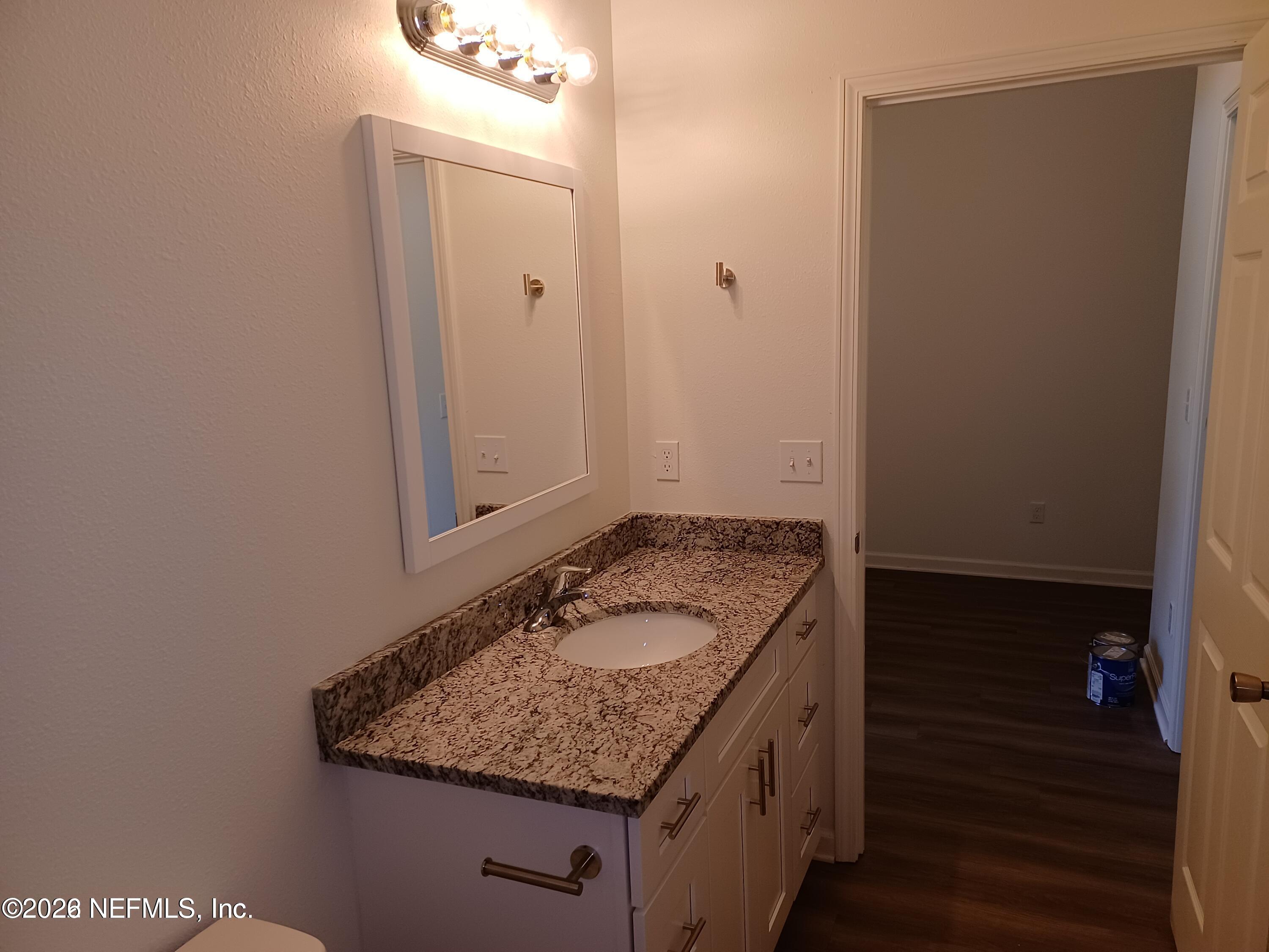 3006 Alonso Road Jacksonville, FL 32216 - Photo 13 of 16 a bathroom with a granite countertop sink and a mirror